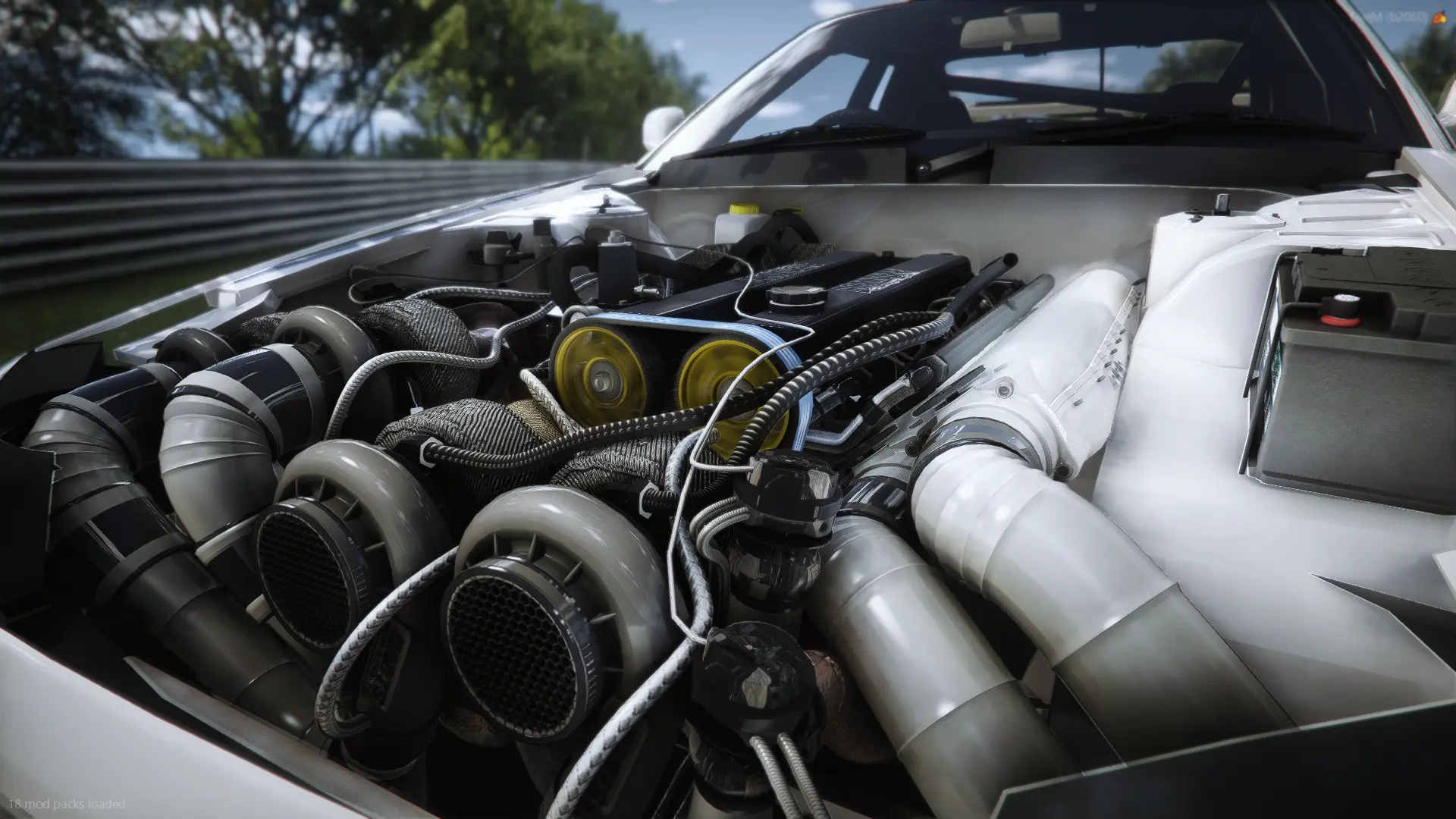 Open hood over a turbocharged engine bay at the track