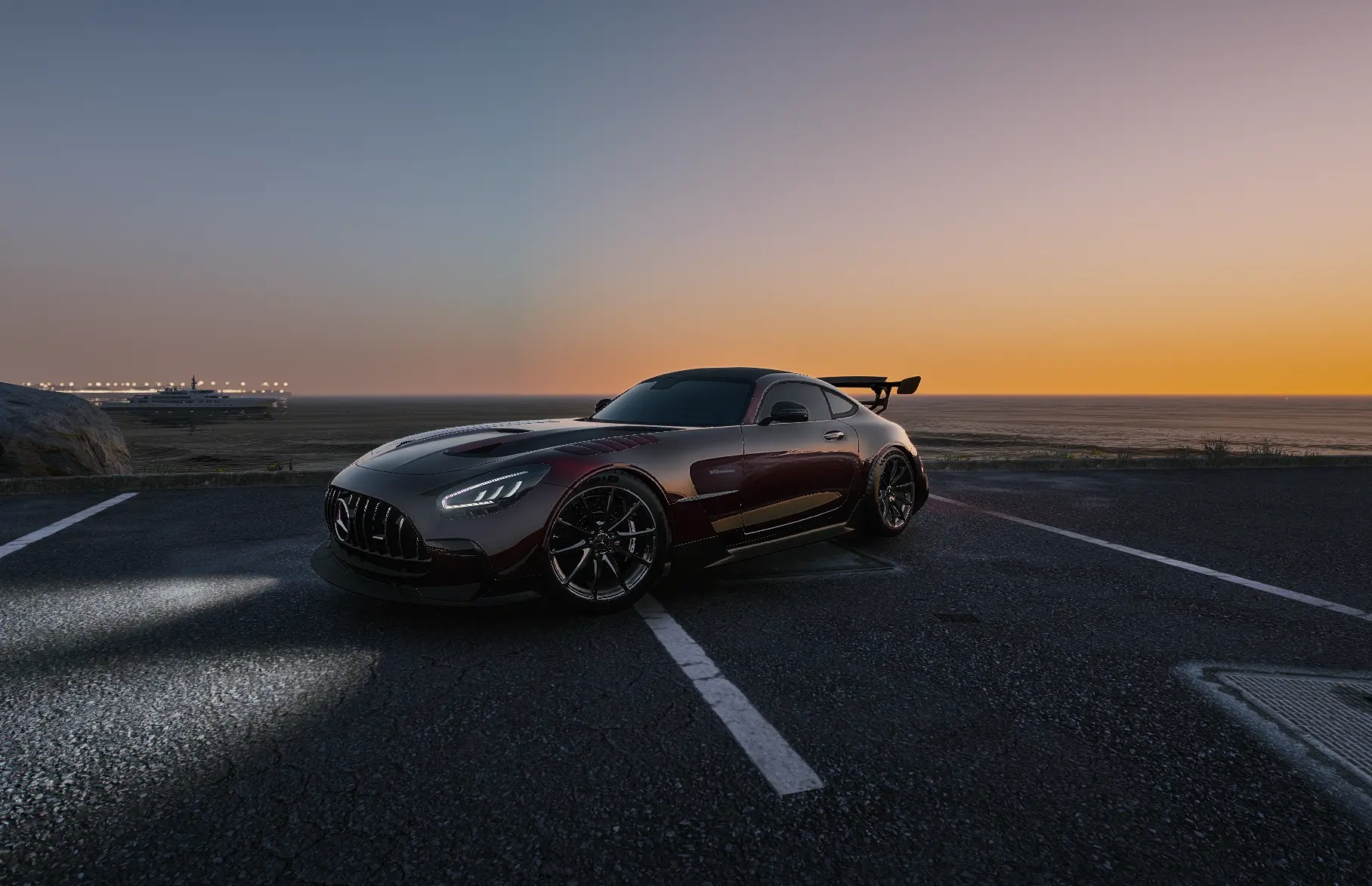 Grey coupe on the coast road at sunset